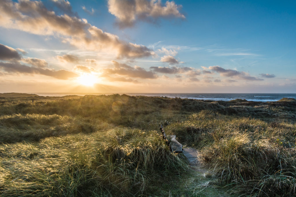 Sonne-ueber-Duene-und-Meer