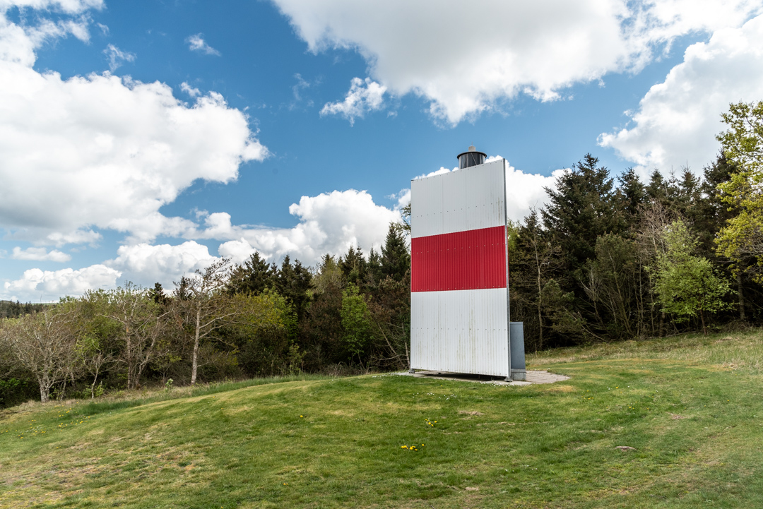 Der Leuchtturm auf Fur. Eine Laterne auf einem Stahlmast, der mit Metallplatten mit schwarzroter Streifenbemalung versehen ist.